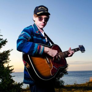 Portrait of Joel Plasket with his guitar