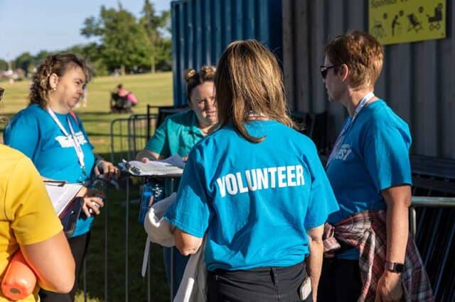 Volunteers working with blue shirts on.