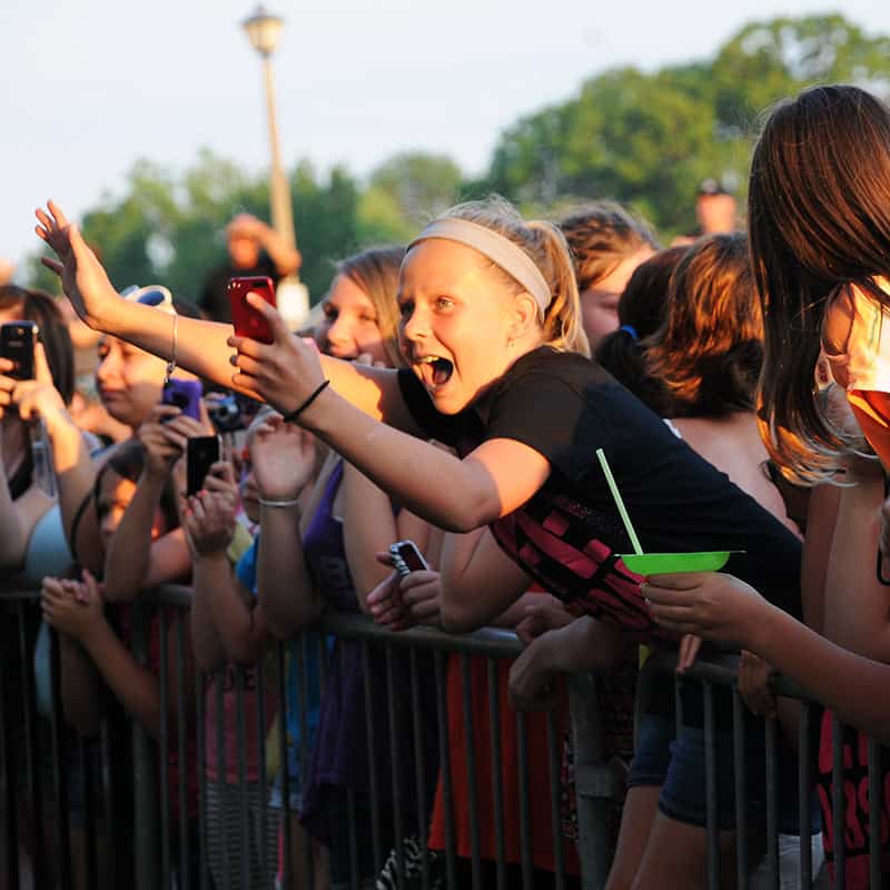 Excited young fan taking photos at a Carly Rae Jepson concert